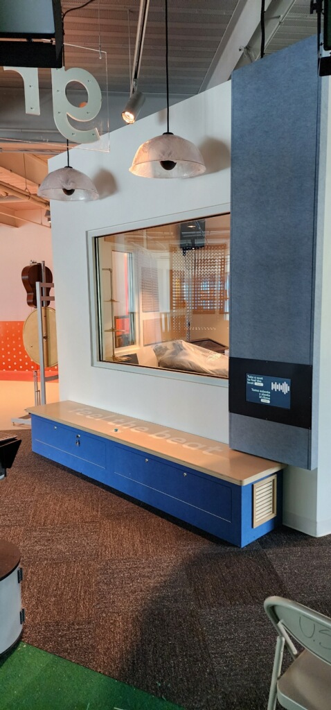 Listening booth exhibit with a bench containing transducers, letting visitors feel music through the seat.
