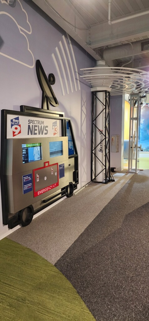 Angled view of the news van broadcast weather exhibit installed in the gallery wall at the Florida Children's Museum.