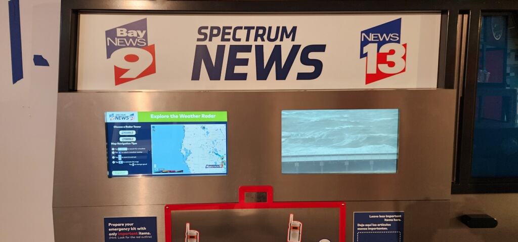 Multiple synchronized touchscreens running the interactive broadcast weather exhibit inside the news van.