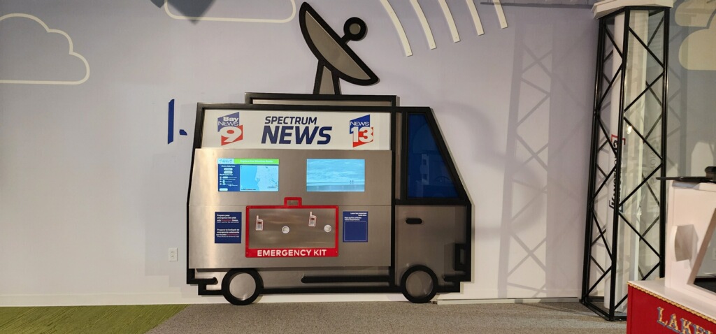Interactive broadcast weather exhibit built into a news van cut into the gallery wall at the Florida Children's Museum in Lakeland.