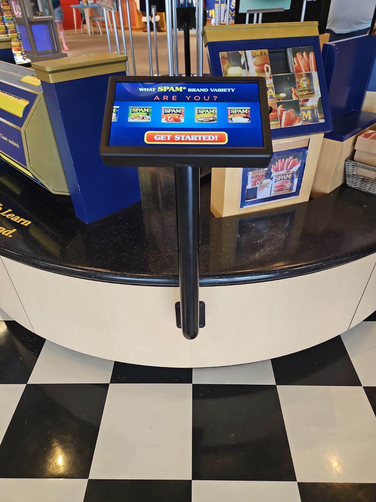 Portrait touchscreen kiosk running an interactive variety quiz, built into exhibit millwork at the SPAM Museum in Austin, Minnesota.